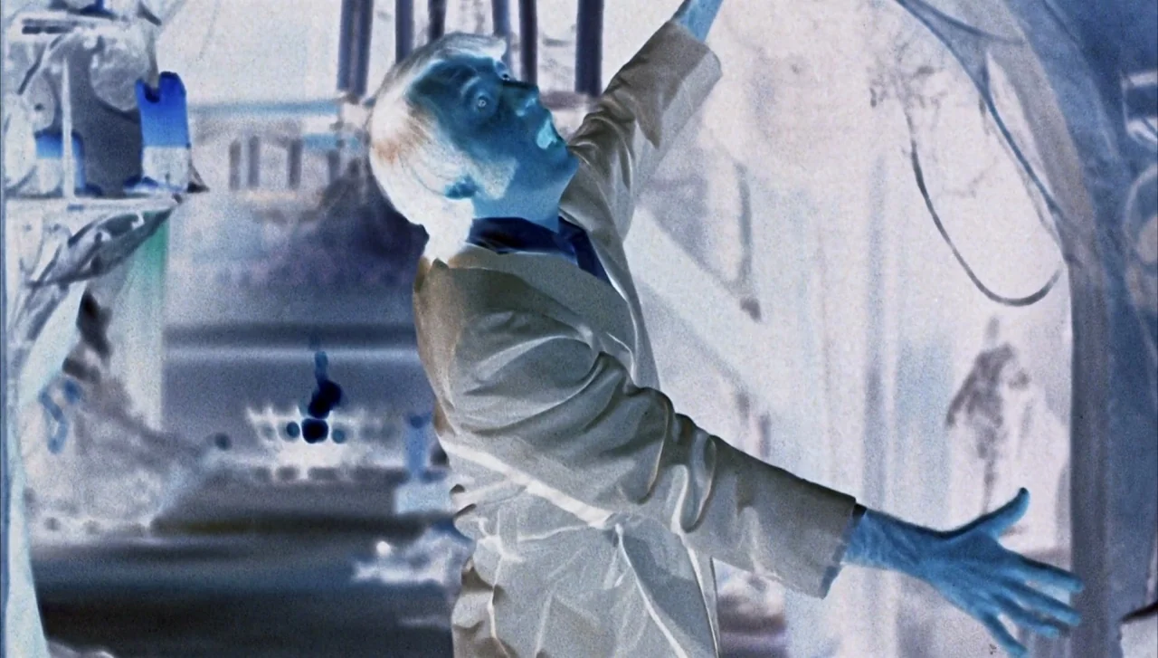 Head (1968) movie still: medium — A science laboratory setting with complex equipment in the background. The man in the lab coat gestures with his…