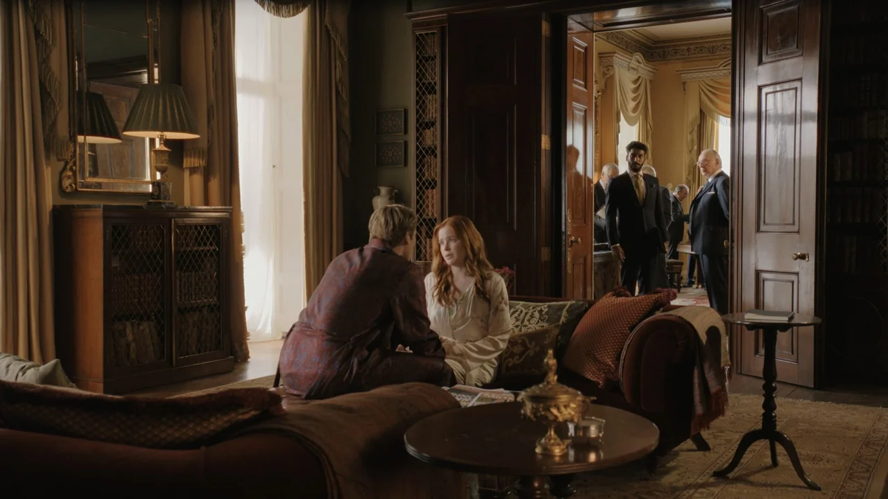 Red, White & Royal Blue (2023) movie still: medium — A well-appointed study features dark wood paneling, ornate furniture, and open double doors.…