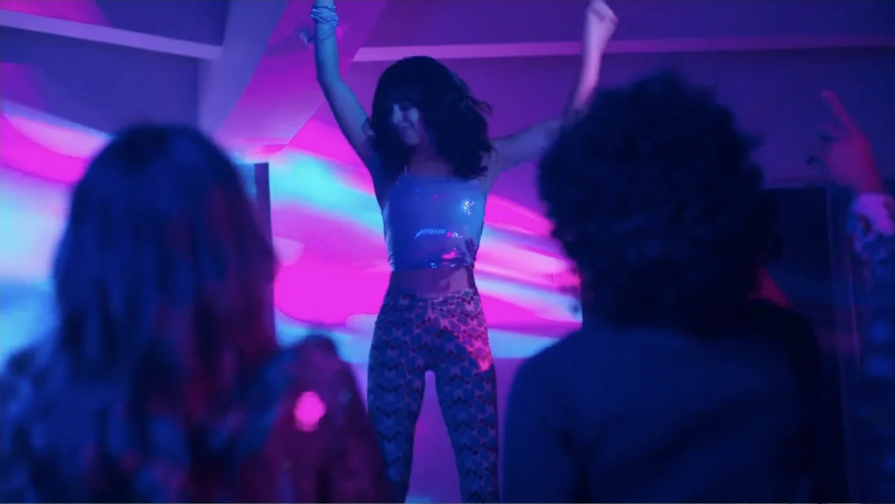 Double Pregnant 2 (2022) movie still: medium — An interior club space features bright neon pink light streaks across the walls. A young woman dances…