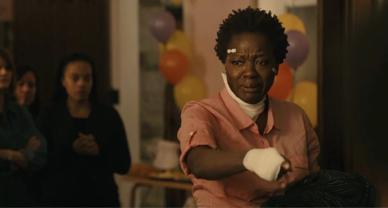 Lila & Eve (2015) movie still: medium — An indoor room decorated with colorful balloons for a party celebration. A woman with a bandaged hand and…