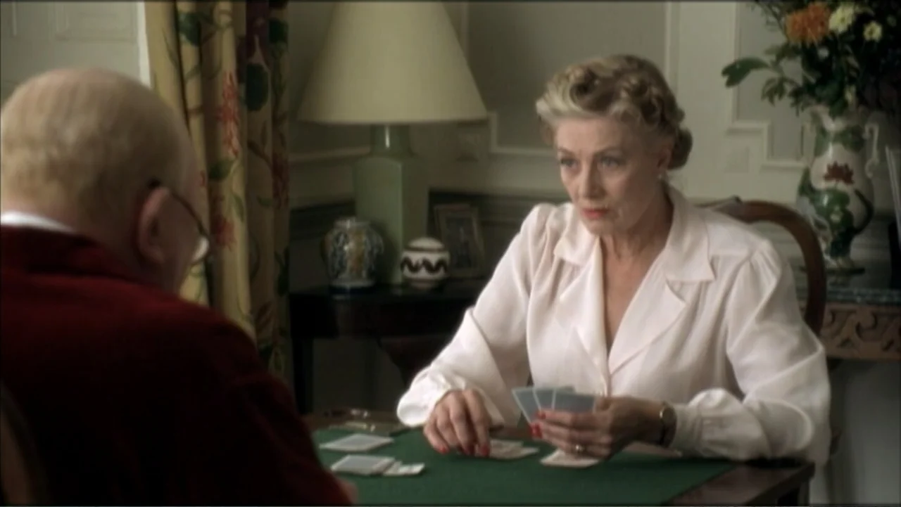 The Gathering Storm (2002) movie still: medium — A quiet room contains a small card table with two individuals playing cards. An elderly woman in a…