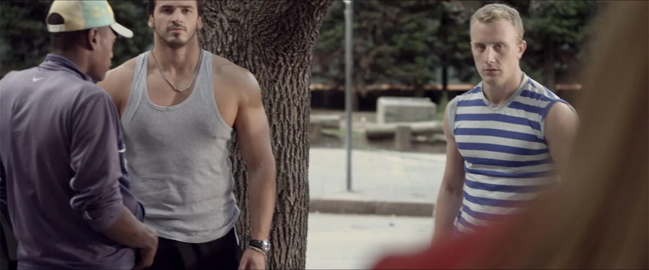 High Five (2004) movie still: medium — A public park setting features a large textured tree trunk between three men. The subjects stand in an open…