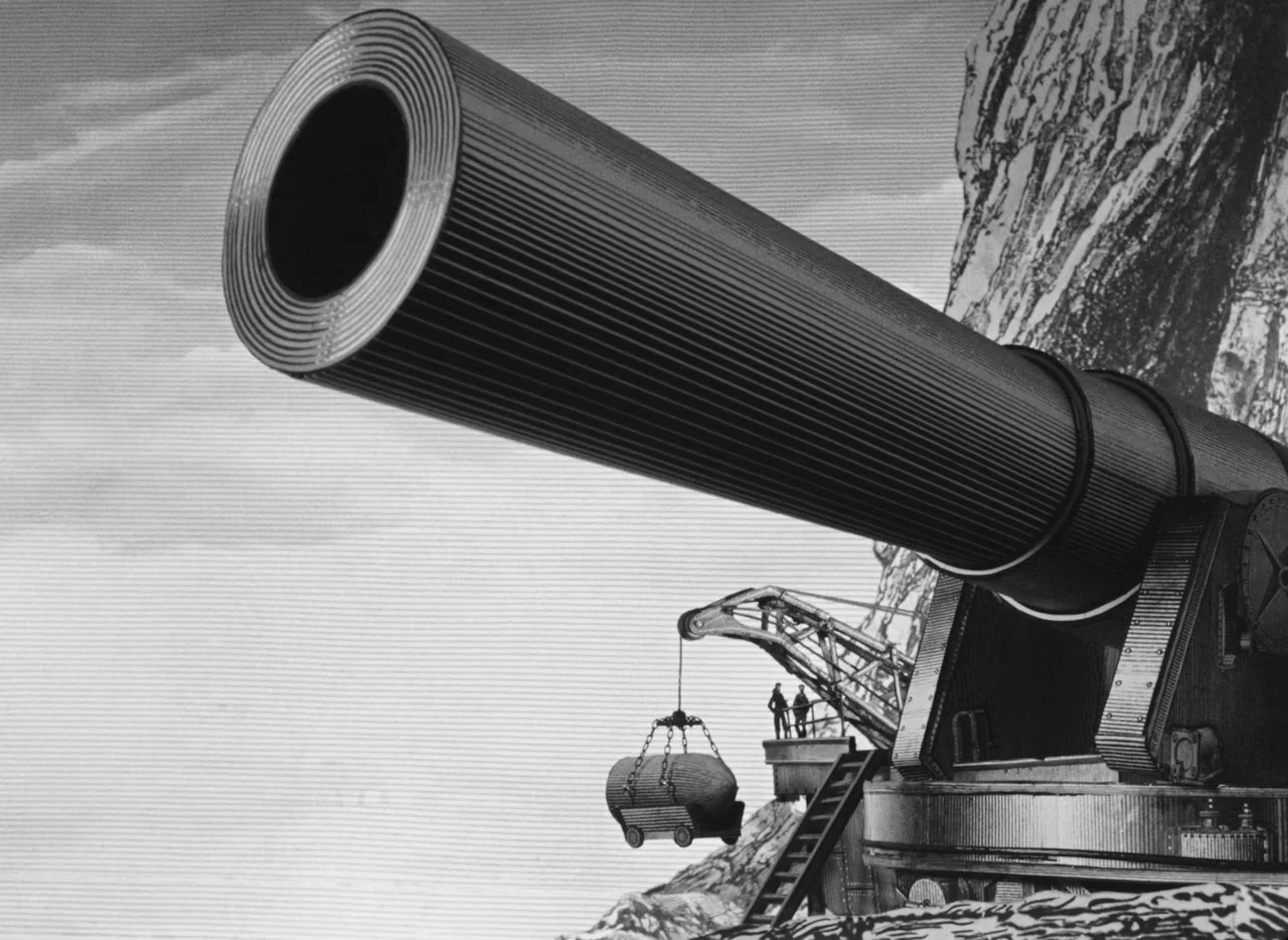 Invention For Destruction (1958) movie still: wide — A massive cannon sits on a platform next to a rugged rock face. A crane lowers a heavy shell…