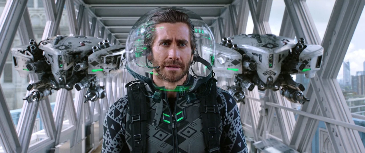 Spider-Man: Far From Home (2019) movie still: medium — A man in a futuristic tactical suit stands inside a glass-enclosed pedestrian walkway. Two…
