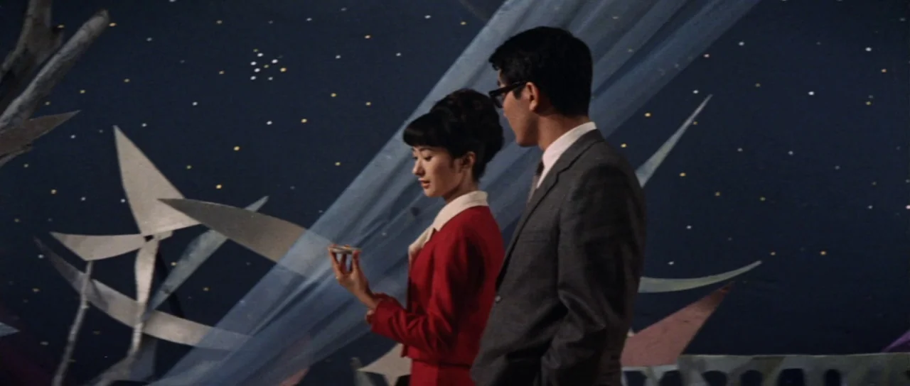 Invasion of Astro Monster (1965) movie still: medium — A theatrical studio set features a dark backdrop decorated with small glowing stars and…
