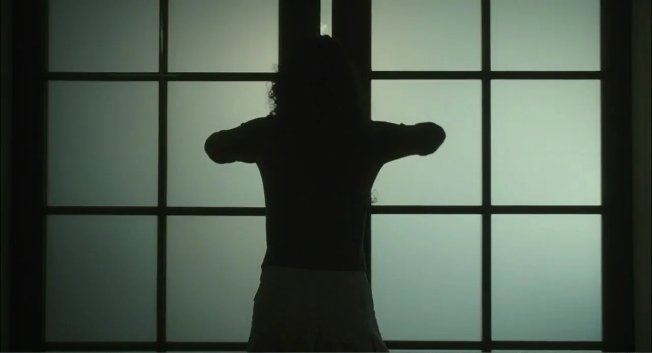 El hijo del diablo (1966) movie still: medium — A dark figure stands in front of a large, multi-paned frosted glass window. The subject is seen from…