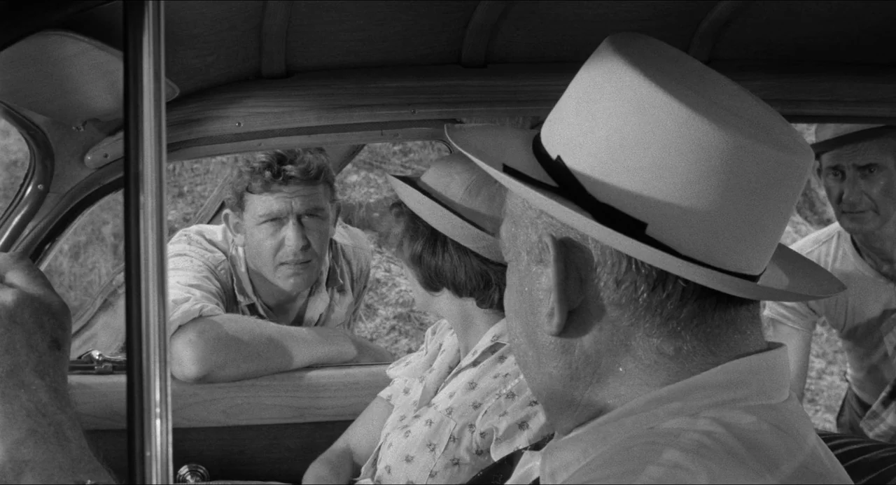 A Face In The Crowd (1957) movie still: medium — The interior of a 1950s automobile provides the setting for a conversation. A man outside the…