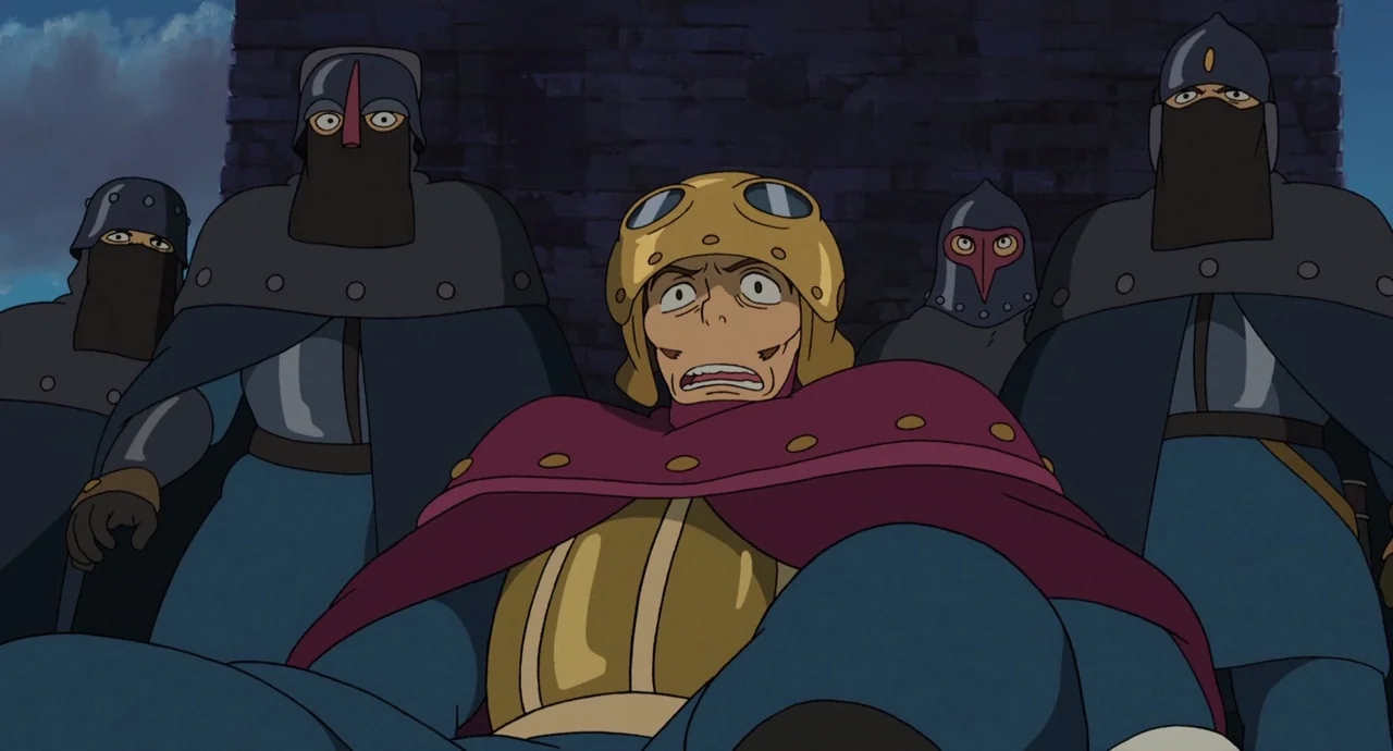 Tales From Earthsea (2006) movie still: medium — A stone wall serves as the background for a group of soldiers. One central man in goggles stands in…
