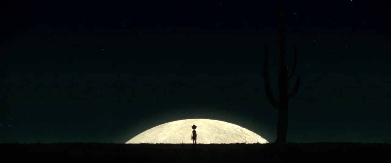 Rango (2011) movie still: wide — A flat desert horizon stretches out under a star-filled night sky. A slender character stands in silhouette before…