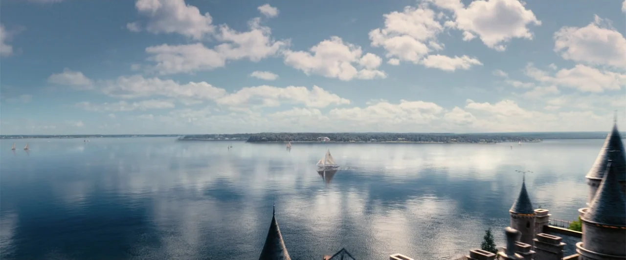 The Great Gatsby (2013) movie still: establishing — A wide view shows a large body of water with distant green treelined shores. Several small…