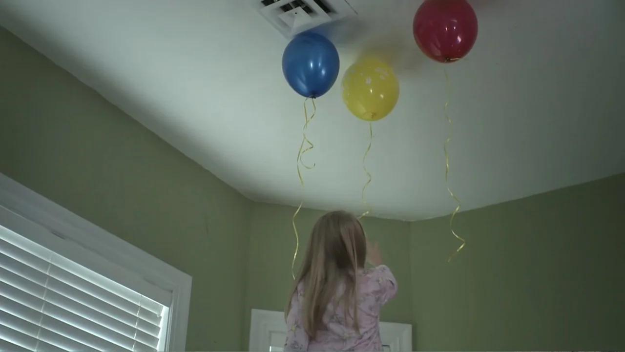 Boathouse Detectives (2010) movie still: medium — A room with pale green walls and a ceiling featuring a central ventilation grate. A child with…