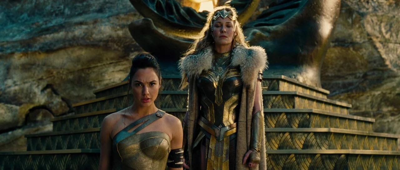 Wonder Woman (2017) movie still: medium — A stone stepped structure with carved patterns stands behind two warriors in fantasy armor. The two women…