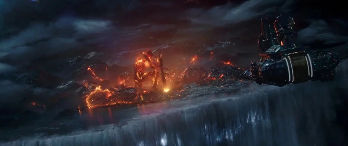 Thor: Ragnarok (2017) movie still: wide — A dark rocky volcanic landscape features rivers of glowing lava beneath a heavy sky. A giant magma…