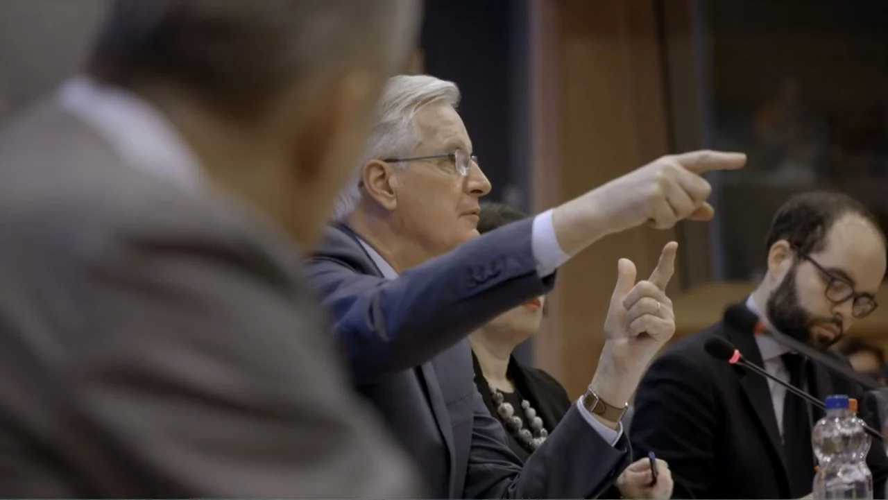 Brexit: Behind Closed Doors (2019) movie still: medium — A professional conference room with multiple seated individuals facing the front of the…