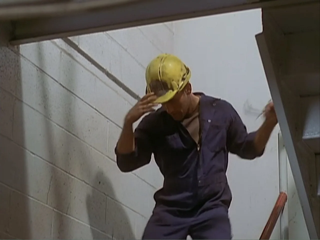 Catch a Falling Star (2000) movie still: medium — A utilitarian industrial stairwell features white painted cinderblock walls and a metal railing. A…