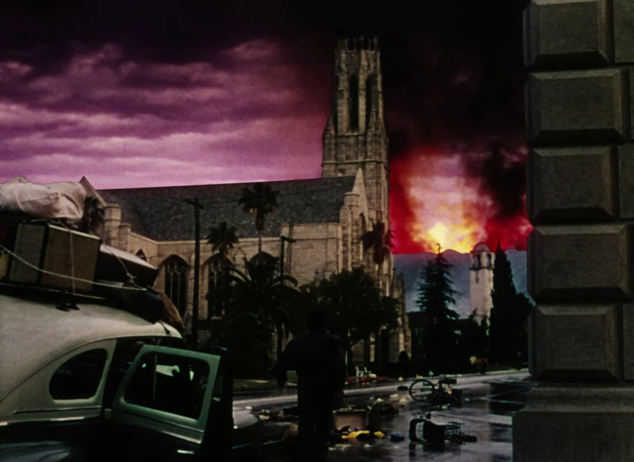 The War of the Worlds (1953) movie still: wide — A stone church stands before a horizon glowing with an intense red and orange fire. A person faces…