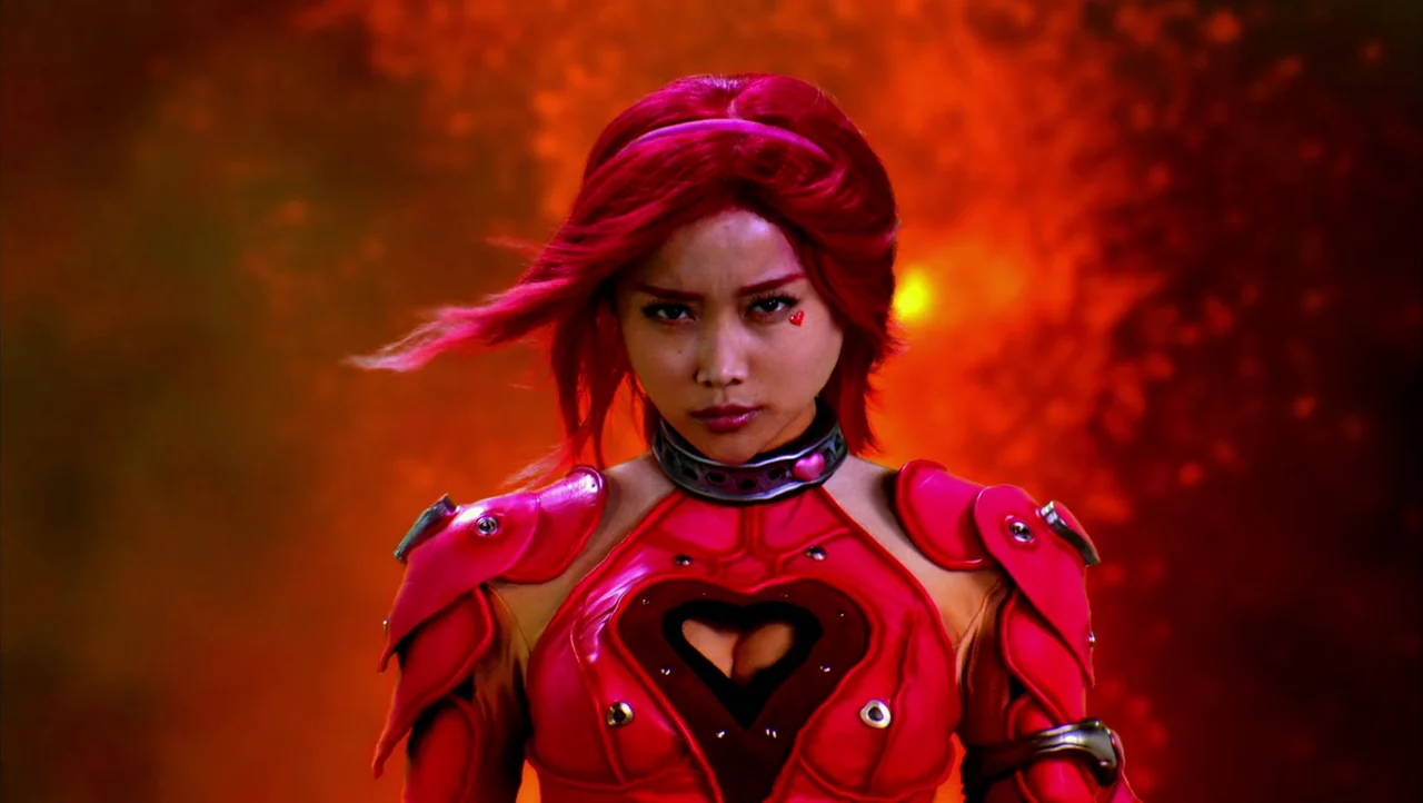 Cutie Honey (2004) movie still: medium — An abstract, intensely vibrant background of swirling fiery orange and red smoke fills space. A woman in…