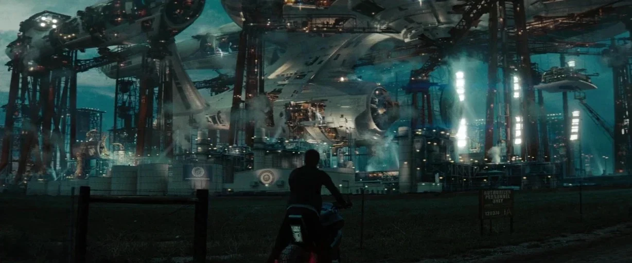 Star Trek (2009) movie still: wide — A massive starship is under construction in a sprawling industrial shipyard at night. A lone individual on a…