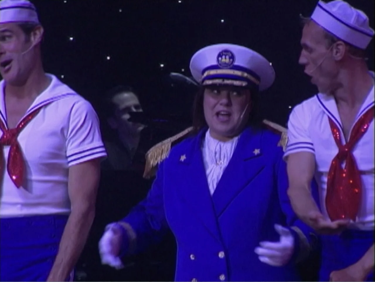 All Aboard! Rosie's Family Cruise (2006) movie still: medium — Three performers in nautical costumes stand on a stage with a dark, speckled…