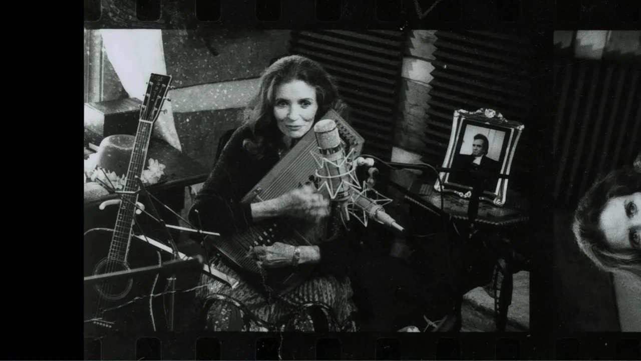 The Winding Stream (2014) movie still: medium — A recording studio interior features acoustic wall panels, a photograph in a frame, and instruments.…
