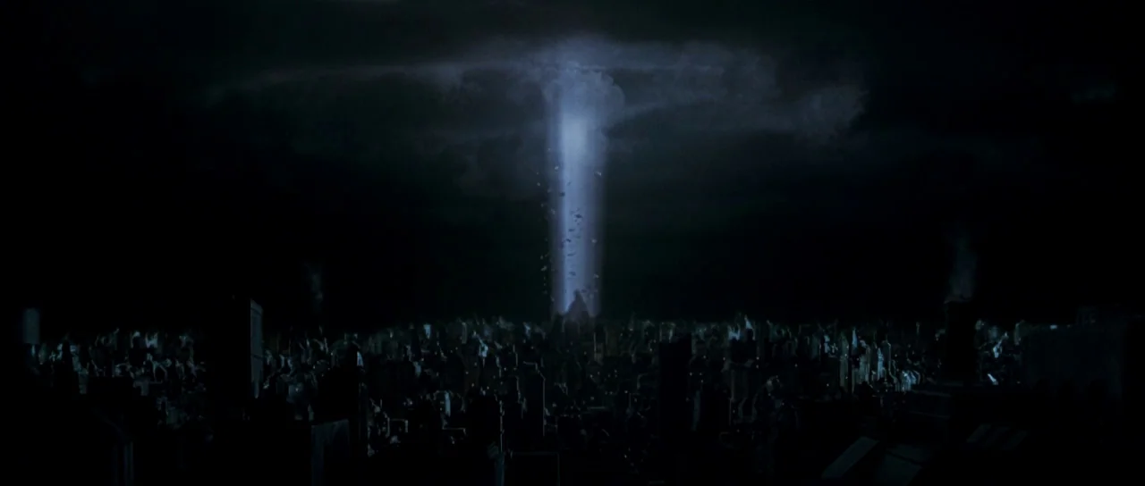 Dark City (1998) movie still: establishing — A dense urban landscape at night sits under a dark, cloudy sky. A brilliant vertical pillar of…