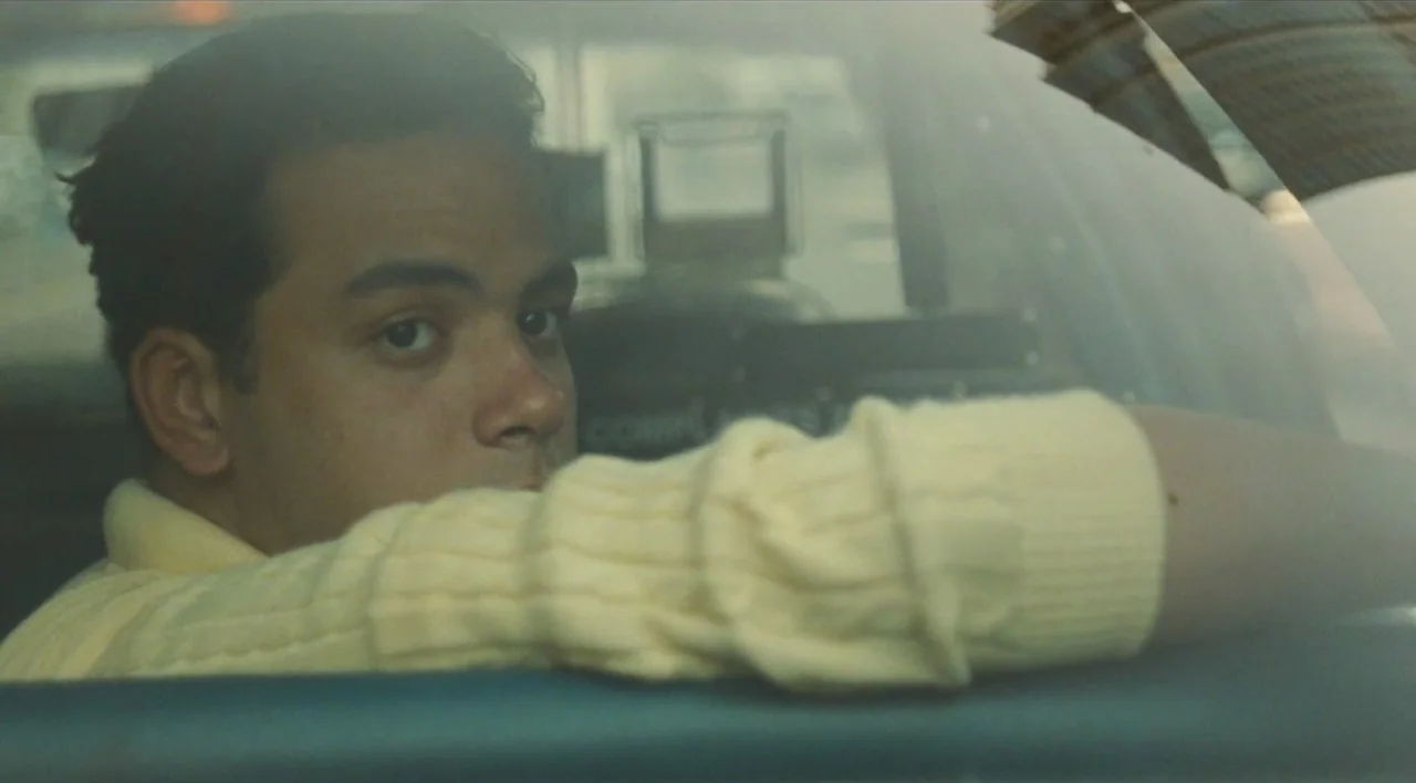 The Other Conquest (1999) movie still: closeup — The interior of a vehicle shows a man looking out from the passenger seat. Through the windshield,…