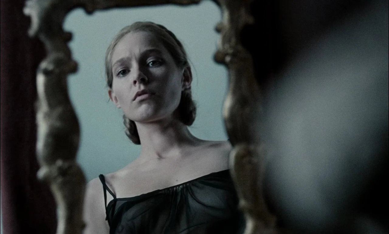 The Third Part of the Night (1971) movie still: closeup — A woman stares into an ornate, antiqued gold-framed mirror in a bright interior space. The…
