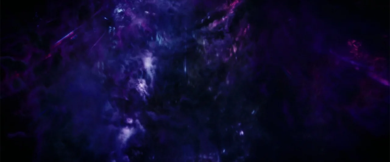 The Tomorrow War (2021) movie still: establishing — A dense cosmic nebula fills the frame with swirling clouds of ionized gas. Wisps of purple and…