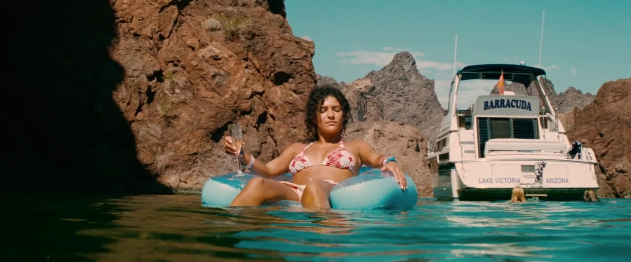 Piranha 3D (2010) movie still: medium — A woman relaxes in a blue inflatable ring in a clear, turquoise desert lake. Rocky canyon walls frame the…