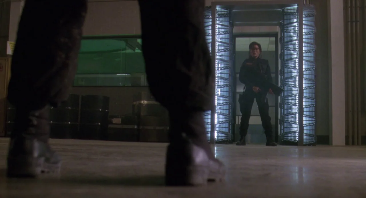 Universal Soldier: The Return (1999) movie still: wide — An industrial facility features a glowing, backlit doorway centered in the rear wall. A…