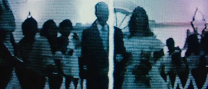 The Headless Woman (2008) movie still: medium — A low-resolution video recording shows a wedding procession in an indeterminate indoor space. A…