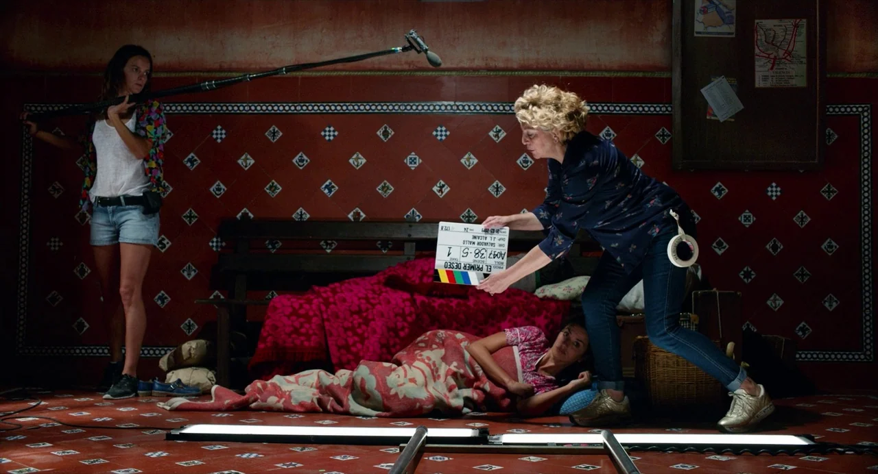 Pain and Glory (2019) movie still: wide — A film set studio designed to look like an interior with red tiles. A film crew member holds a…