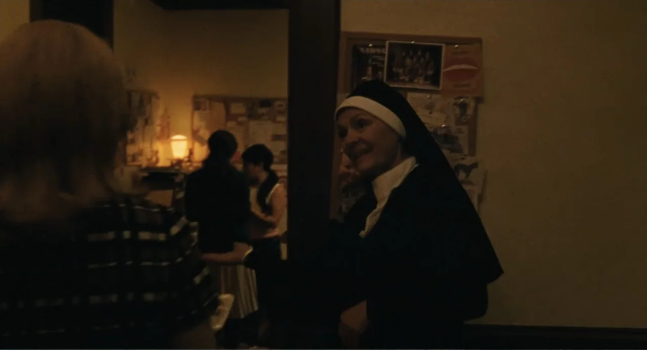 Call Jane (2022) movie still: medium — An interior office with a corkboard covered in papers and a small lamp. A nun stands near the doorway…