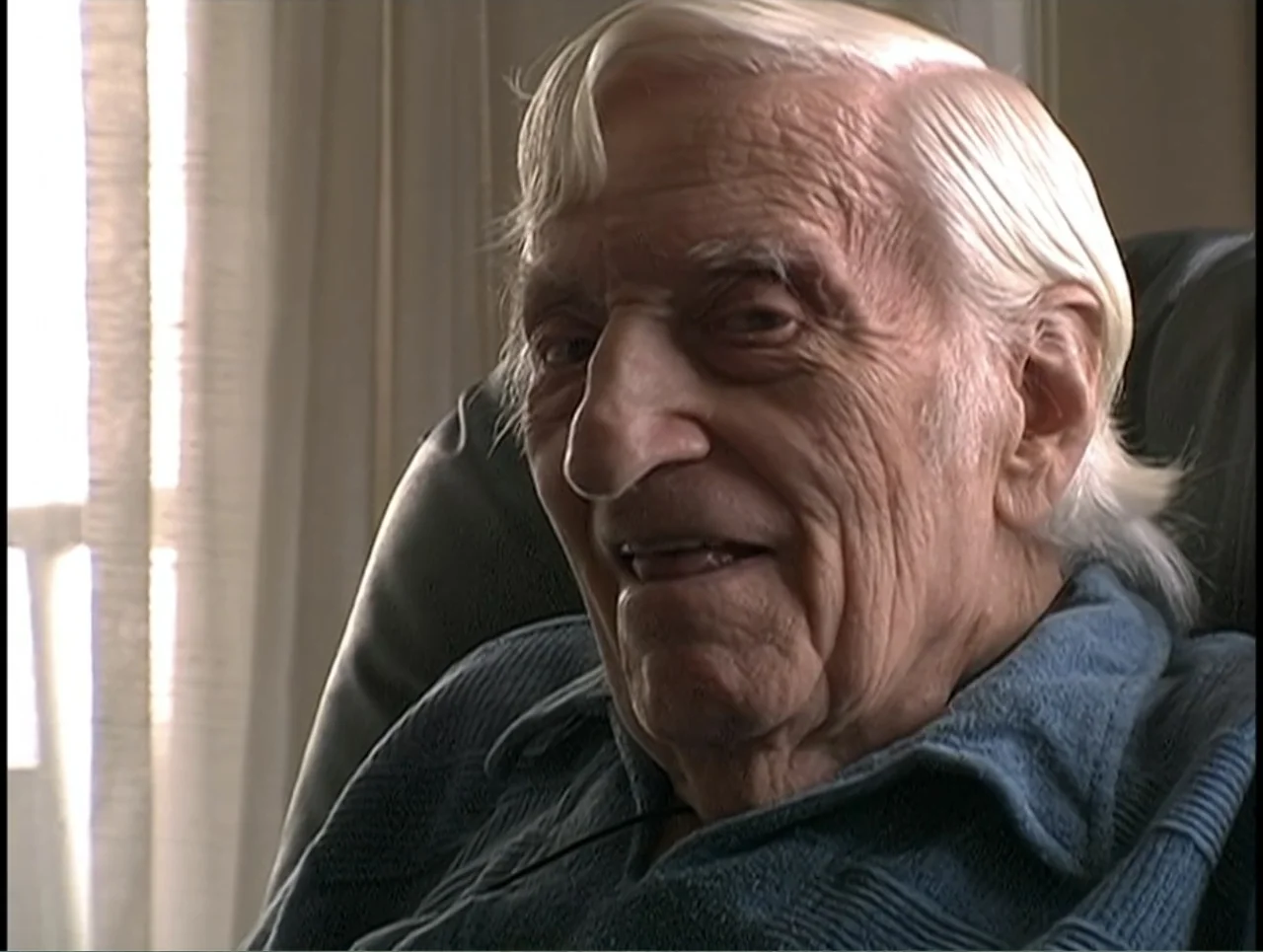 First Cousin Once Removed (2012) movie still: closeup — A residential interior features a white curtained window visible behind the main subject. An…
