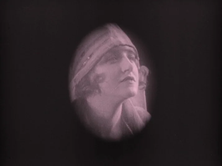 Making of: The Wheel (La Roue) (1923) movie still: closeup — A woman is centered in an oval vignette against a dark background. She wears a period…