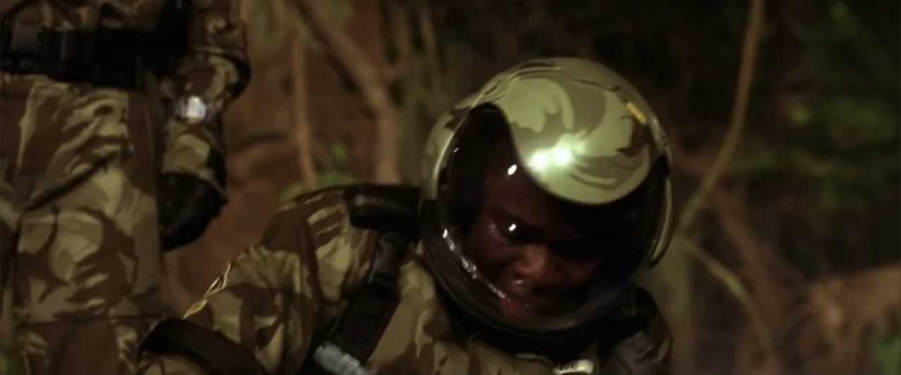 A Sound of Thunder (2005) movie still: medium — A dense outdoor environment with thick foliage and blurred brown and green tones. A soldier in a…