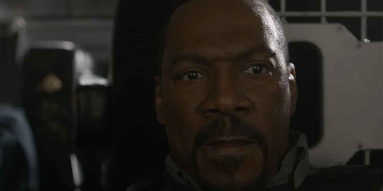 The Pickup (2025) movie still: closeup — A close view inside a vehicle cabin featuring a dark, metallic security partition. A man stares directly…