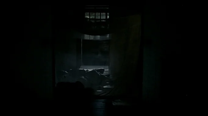 A Time To Love and A Time To Die (1985) movie still: wide — A dark prison cell features a single barred window letting in faint daylight. A fabric…