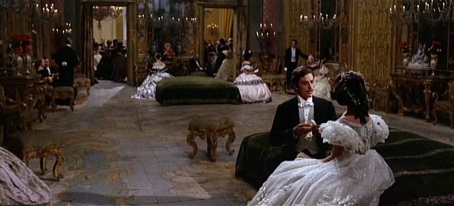 The Leopard (1963) movie still: fullbody — A grand 19th-century ballroom features gold wall panels, crystal chandeliers, and patterned tile floors.…