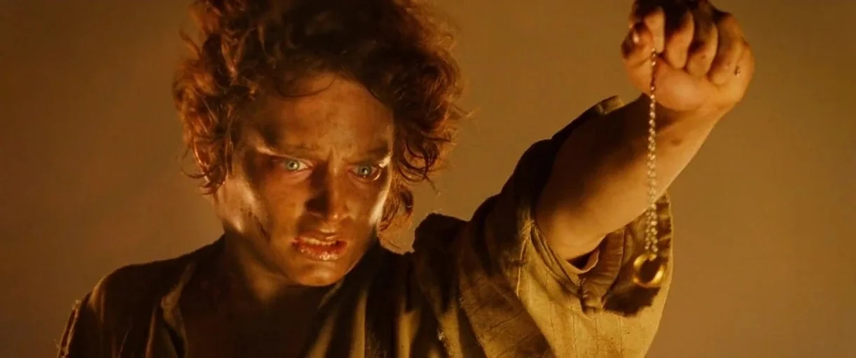 The Lord of The Rings: The Return of the King (2003) movie still: closeup — A dark, warm-toned interior space with a dimly lit background. A man…