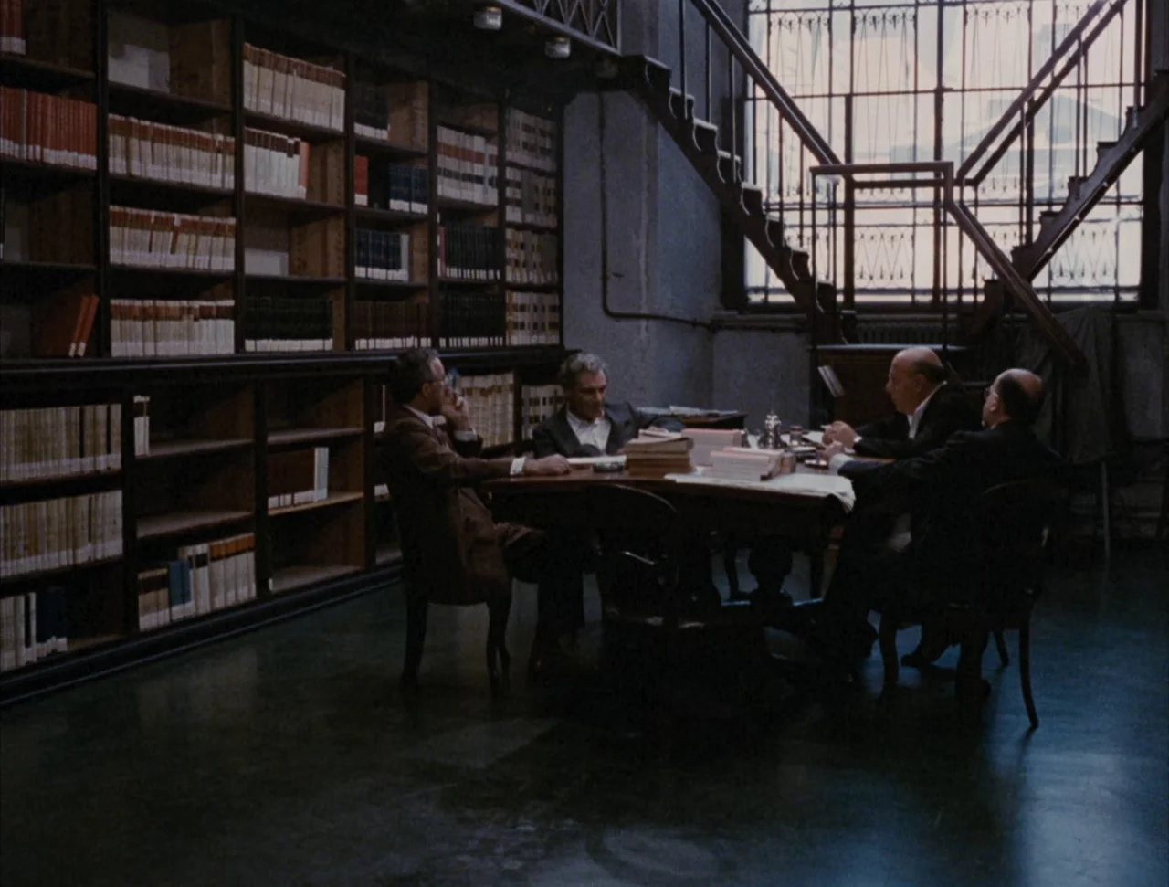 Christ Stopped at Eboli (1979) movie still: wide — A spacious room contains tall wooden bookshelves filled with leather-bound volumes and a…