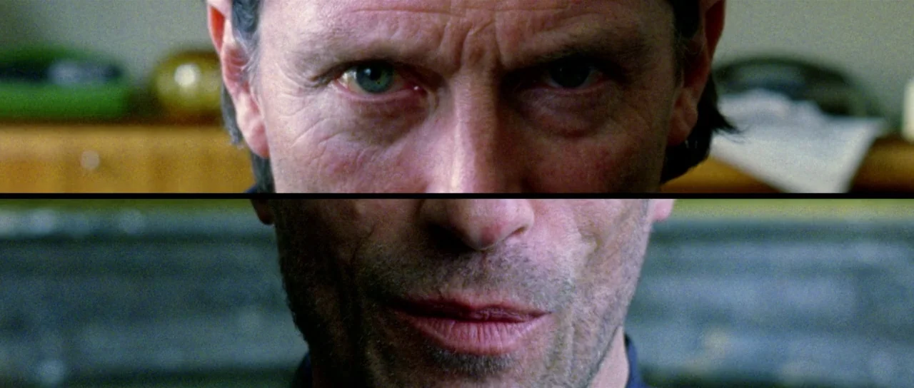 The Strange Colour of Your Body’s Tears (2013) movie still: closeup — A man's face is presented as a split-screen composite. The subject stares…