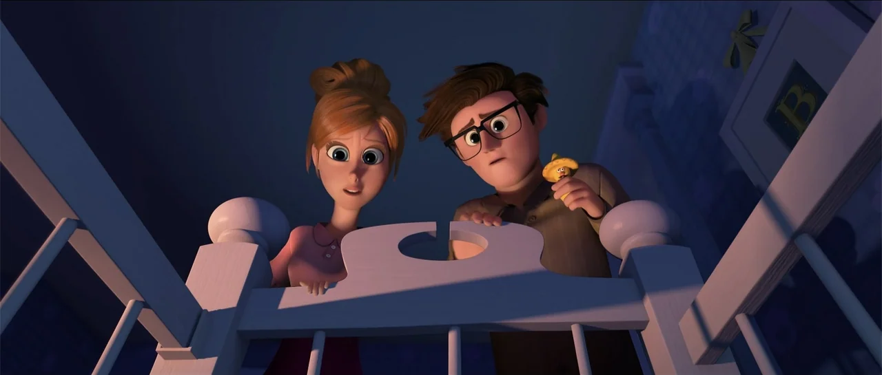The Boss Baby (2017) movie still: medium — A dimly lit room with a wooden crib in the foreground. A man and woman stare down into the crib with…