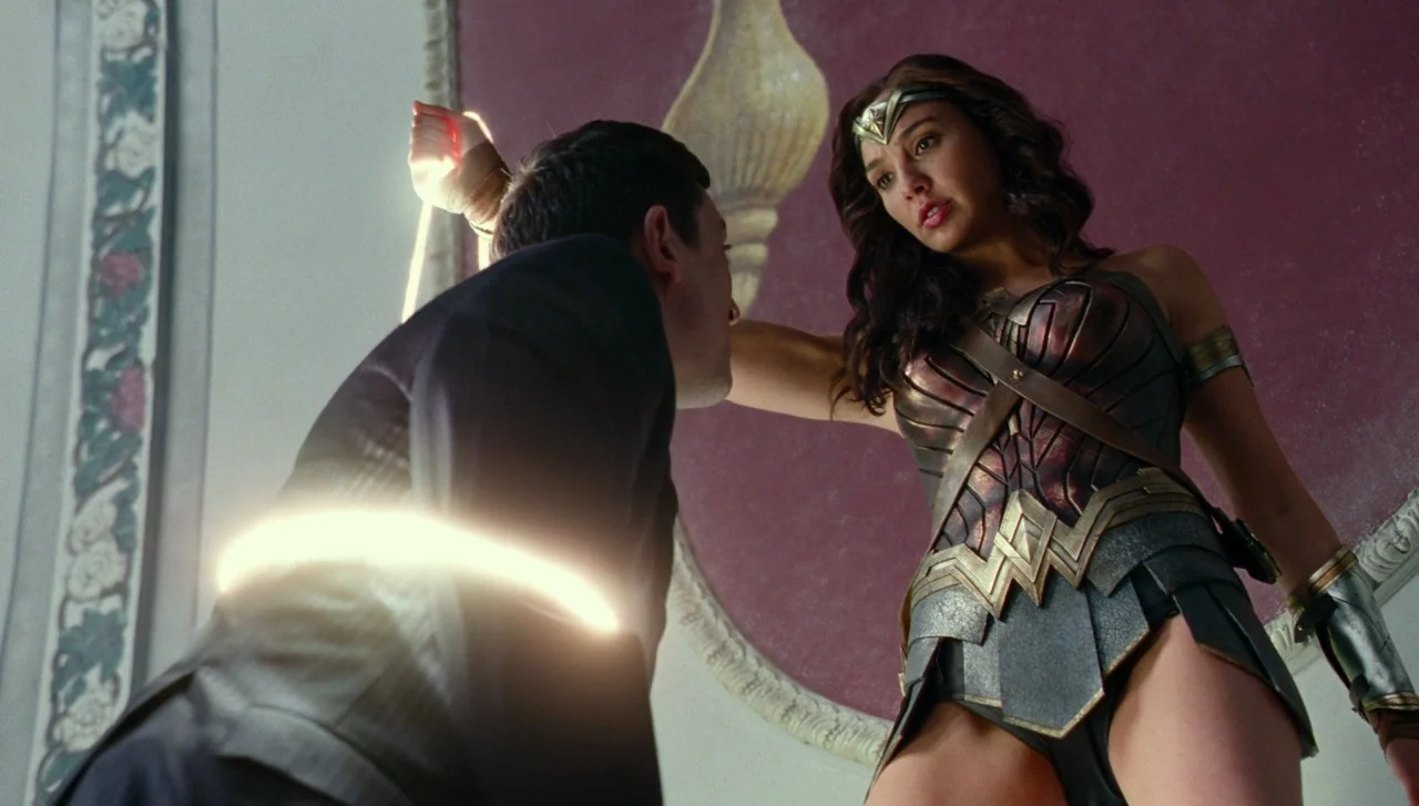 Justice League (2017) movie still: medium — An opulent interior features a dark red wall panel with ornamental molding. A female warrior in armor…