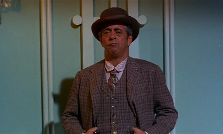 Frankie and Johnny (1966) movie still: medium — A man in period clothing stands before a pale green wall with decorative molding. He keeps his hands…