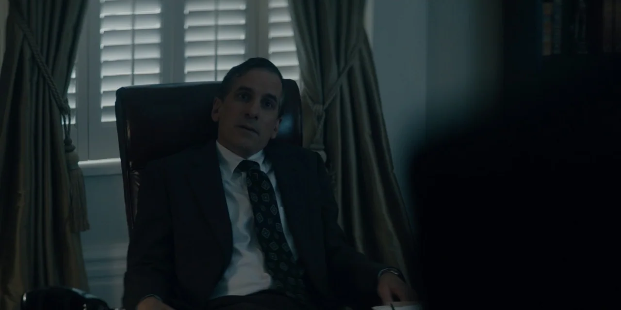Mark Felt: The Man Who Brought Down the White House (2017) movie still: medium — A man in a suit sits in a dark office in front of shuttered…