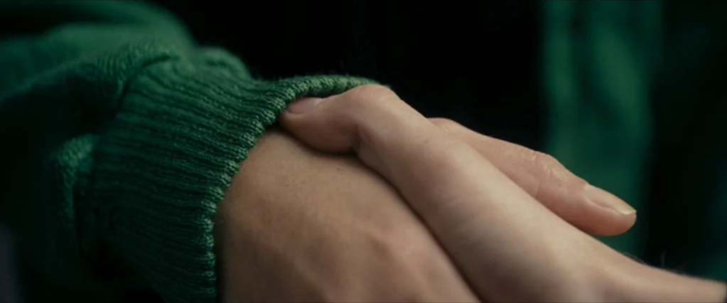 The Brothers Bloom (2008) movie still: closeup — A close-up shot focuses on two hands holding each other. One hand is partially covered by a…