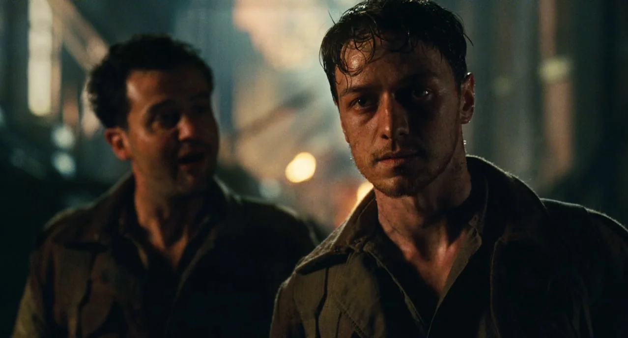 Atonement (2007) movie still: medium — A dark, smoky battlefield at night with glowing embers in the background. Two male soldiers in military…