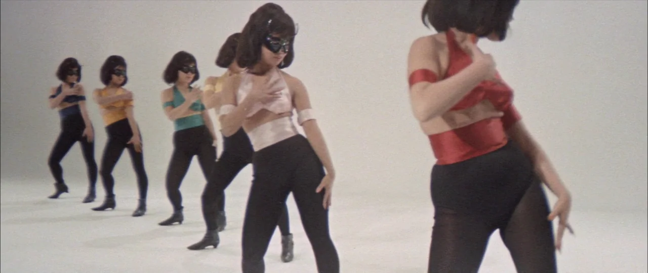 Black Tight Killers (1966) movie still: fullbody — A group of dancers perform in a minimalist, all-white studio environment. The women wear matching…