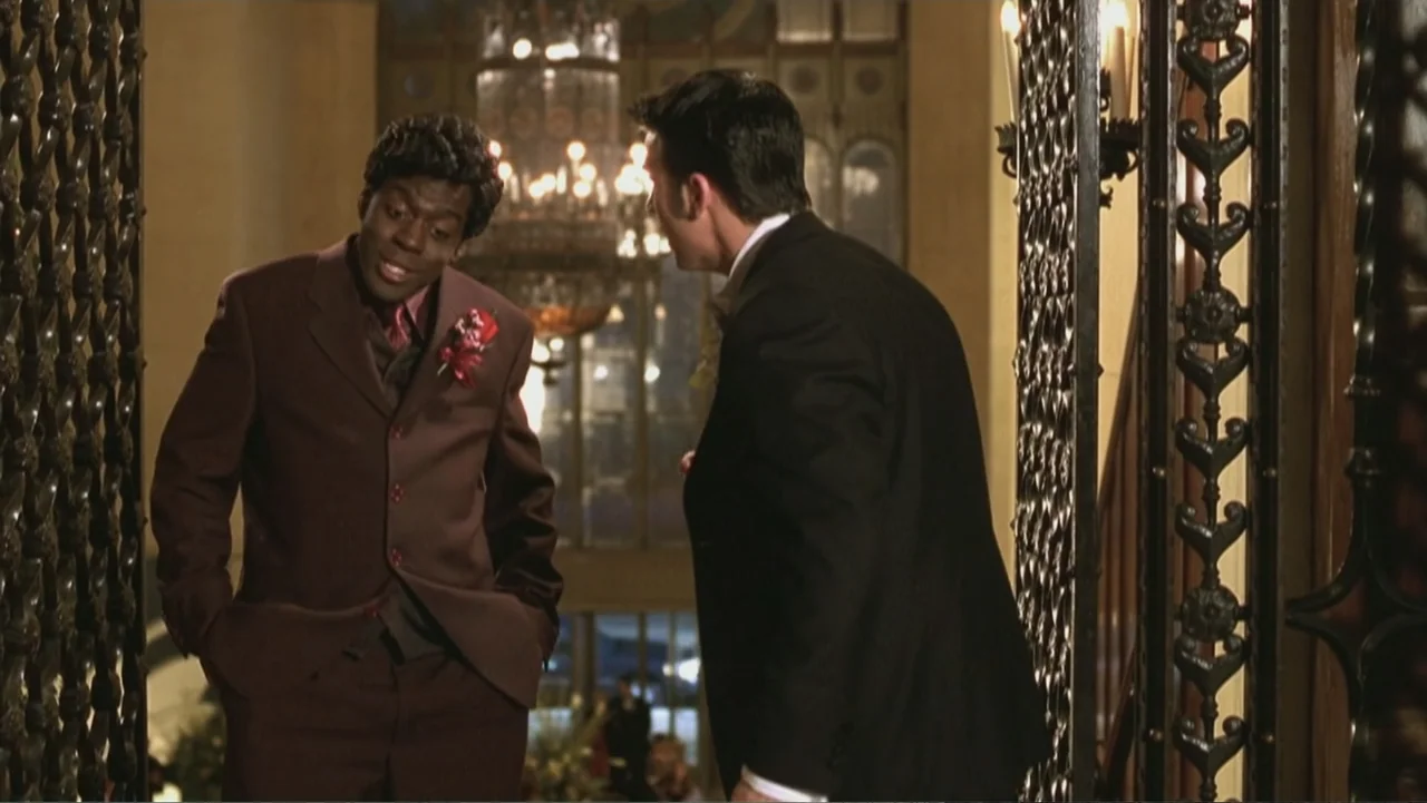Not Another Teen Movie (2001) movie still: medium — An upscale hotel interior features an ornate wrought iron screen and a central chandelier. Two…